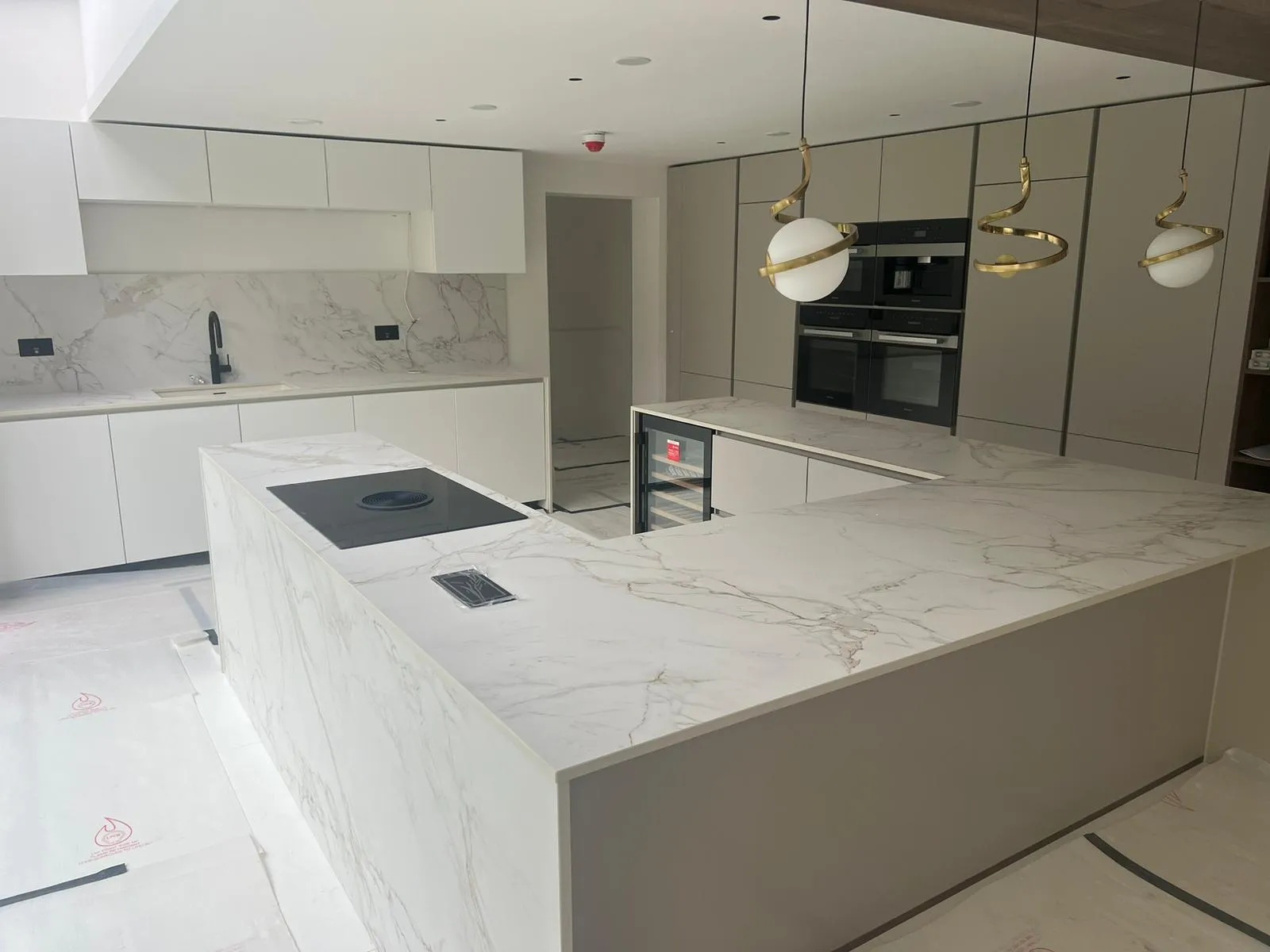 A kitchen with a marble counter top and oven.